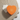 A heart-shaped orange Venchi gift box sits on a textured beige cloth beside an envelope and a “Best wishes” card with a floral pattern.