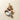 Assorted chocolates, candy eggs, nuts, and a piece of white meringue arranged in a scattered pattern on a light beige background.